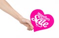 Valentine's Day and sale topic: Hand holding a card in the form of a pink heart with the word Sale isolated on white background Royalty Free Stock Photo