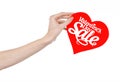 Valentine's Day and sale topic: Hand holding a card in the form of a red heart with the word Sale isolated on white background Royalty Free Stock Photo