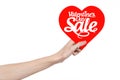 Valentine's Day and sale topic: Hand holding a card in the form of a red heart with the word Sale isolated on white background Royalty Free Stock Photo