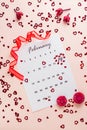 Valentine`s Day. Small red hearts highlight the date February 14 on a calendar sheet, dry flowers and a red ribbon on a pink hear Royalty Free Stock Photo