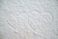 Valentine`s Day. Symbol of love, two hearts drawn on white snow in the frosty winter day at sunset Royalty Free Stock Photo