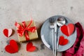 Valentine`s Day Table Setting. Gift box, plate with cutlery, festive doceration. Flat lay, top view Royalty Free Stock Photo