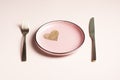 Valentine`s Day table setting, pink plate with golden heart on powdery background