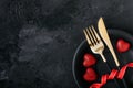 Valentine`s Day table setting with plate, gold knife, fork, red ribbon and hearts Royalty Free Stock Photo