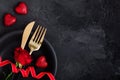 Valentine`s Day table setting with plate, gold knife, fork, red rose, ribbon and hearts Royalty Free Stock Photo