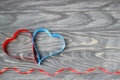 Valentine`s Day . Two hearts of ribbons of red and blue on a bac