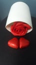 Valentine`s Day two red hearts, red rose in white vase. Black bacground.