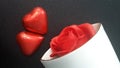 Valentine`s Day two red hearts, red rose in porcelain vase. Black bacground. Royalty Free Stock Photo