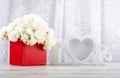 Bouquet of white roses in a red box and a white photo frame close-up. Royalty Free Stock Photo