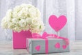 White roses in a pink square box, gift box and a symbol of the heart for the inscription close-up. Royalty Free Stock Photo