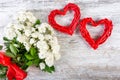 A bouquet of white roses with a red ribbon and two frames of red rattan hearts for an inscription or photo. Royalty Free Stock Photo