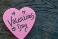 ValentineÃ¢â¬â¢s Day wrote text on pink love heart with drawn hearts. On rustic wooden background. Love Valentines concept