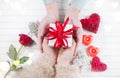 Valentine`s Day. Young couple hands holding gift box over white wooden background Royalty Free Stock Photo