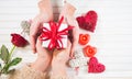 Valentine`s Day. Young couple hands holding gift box over white wooden background. Love concept. Top view