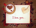 Valentine`s postcard. Cup of coffee on open book with wooden heart on it. Royalty Free Stock Photo