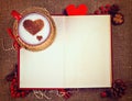 Valentine`s postcard. Cup of coffee on open book with wooden heart on it. Royalty Free Stock Photo