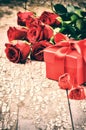 Valentine's setting with bouquet of red roses and present Royalty Free Stock Photo