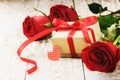 Valentine's setting with bouquet of red roses and present Royalty Free Stock Photo