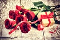 Valentine's setting with bouquet of red roses and present in box Royalty Free Stock Photo