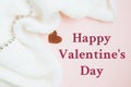 Valentine's Day background. Red heart and folds white knitted fabric on pastel pink background