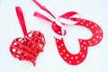 Valentine's day concept. Two red hearts. Wooden heart with white dots and a ribbon bow on a stick. Wicker heart with