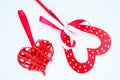 Valentine's day concept. Two red hearts. Wooden heart with white dots and a ribbon bow on a stick. Wicker heart with a