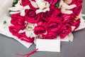 Valentine's day flowers. Bouquet of red roses and white orchids with blank note. Present gift for holiday. Space Royalty Free Stock Photo