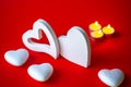 Valentine& x27;s Day - White big hearts on the red background of the ass lit romantic candles . An atmosphere of love and Royalty Free Stock Photo