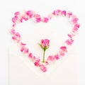 Valentines background. Heart symbol. Petals of roses and vintage paper cards on white background. Flat lay, Top view. Royalty Free Stock Photo