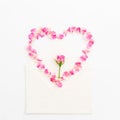Valentines background. Heart symbol. Petals of roses and vintage paper cards on white background. Flat lay, Top view. Royalty Free Stock Photo