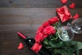 Valentines card with romantic red roses, wine bottle, heart and red gift box on wooden table. Top view with space