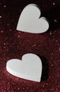 Valentines day abstract background. Shiny sparkle red metallic glitter texture. White decorative Hearts on gules shiny background Royalty Free Stock Photo