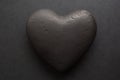 Valentines day background. Close-up of black textured heart, on black