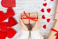 Valentines Day background. girl hand give valentine gift box with a red heart inside on a white old wooden table. Valentine day Royalty Free Stock Photo