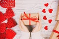 Valentines Day background. girl hand give valentine gift box with a red heart inside on a white toned, vintage old wooden table. Royalty Free Stock Photo