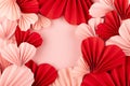 Valentines day background - many gentle pink and red hearts of chinese paper fans on pastel pink color as frame with copy space.