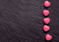 Valentines day background. Pink heart shaped pills or candy on grunge black slate background. Royalty Free Stock Photo