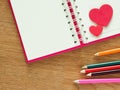 Valentines day background with red hearts, book for diary and color pencils on wood floor. Love and Valentine concept Royalty Free Stock Photo