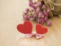 Valentines day background with red hearts on wood floor and blurred pink roses in background. Love concept Royalty Free Stock Photo