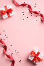 Valentines day banner design. Top view gifts, red ribbon, confetti on pink background. Lover, romance concept Royalty Free Stock Photo