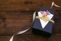 Valentines day, birthday Craft gift box with decor Black paper present box with heart, lace napkin, jute rope on wooden background