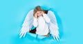 Valentines day. Blonde cute child in angel wings. Cupid boy. Angelic kid in paper hole. Banner. Royalty Free Stock Photo