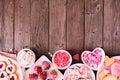 Valentines Day bottom border of assorted sweets and cookies, above view over a wood background with copy space