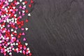 Valentines Day candy heart sprinkles side border over a black background Royalty Free Stock Photo