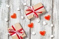 Valentines Day candy hearts marshmallows and box of gifts in craft paper over white wooden background Royalty Free Stock Photo