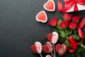 Valentines day card. Rose red flowers brownie cookies and chocolate candy on heart shaped, gift box with wine on black background. Royalty Free Stock Photo