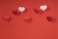 2 white and 5 red flying small textile hearts and their shadows are on a background of red velvet paper