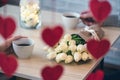 Valentines day. Close-up of woman and man celebrating in restaurant. Boyfriend giving bouquet of flowers tulips to girlfriend. Vi