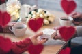 Valentines day.  Close-up of woman and man celebrating in restaurant. Boyfriend giving small box gift to girlfriend. View through Royalty Free Stock Photo