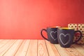 Valentines day concept with chalkboard coffee mugs, heart shapes and gift box on wooden table